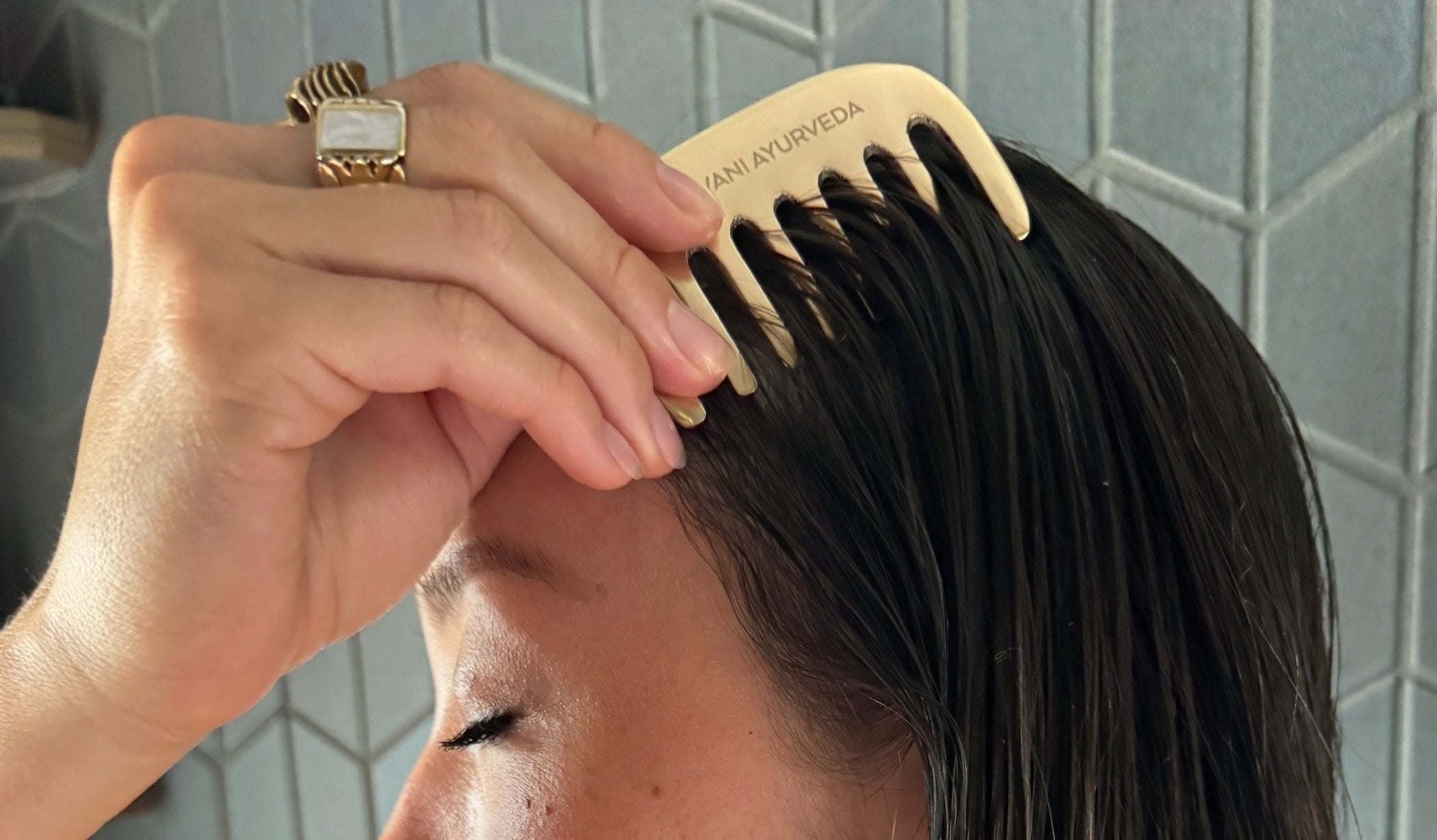 Woman holding PAAVANI Herbal Hair Oil and Kansa Comb - the complete Hair Care Ritual