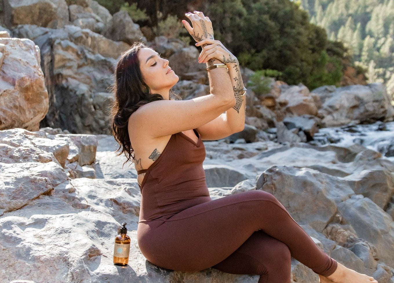 Woman applying PAAVANI Ayurveda Pitta Body Oil in the morning sunshine