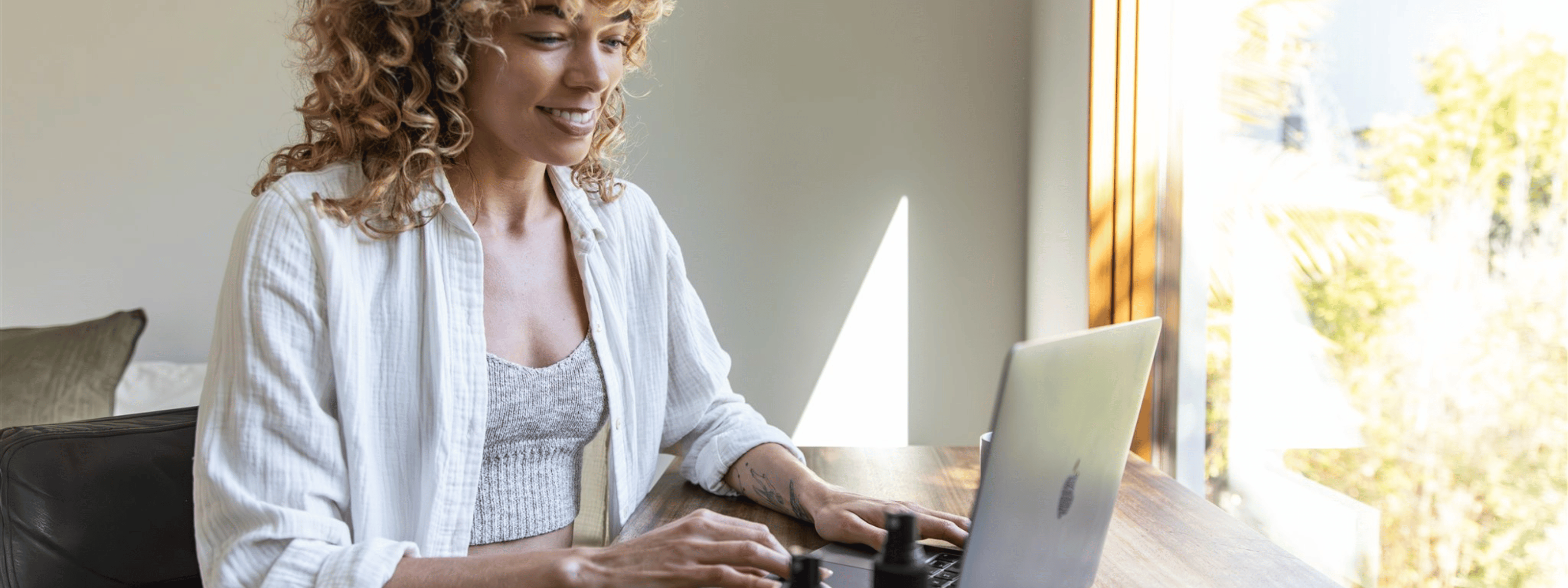 Woman feeling calm and balanced while working on a laptop after practicing Ayurvedic rituals for digital overload
