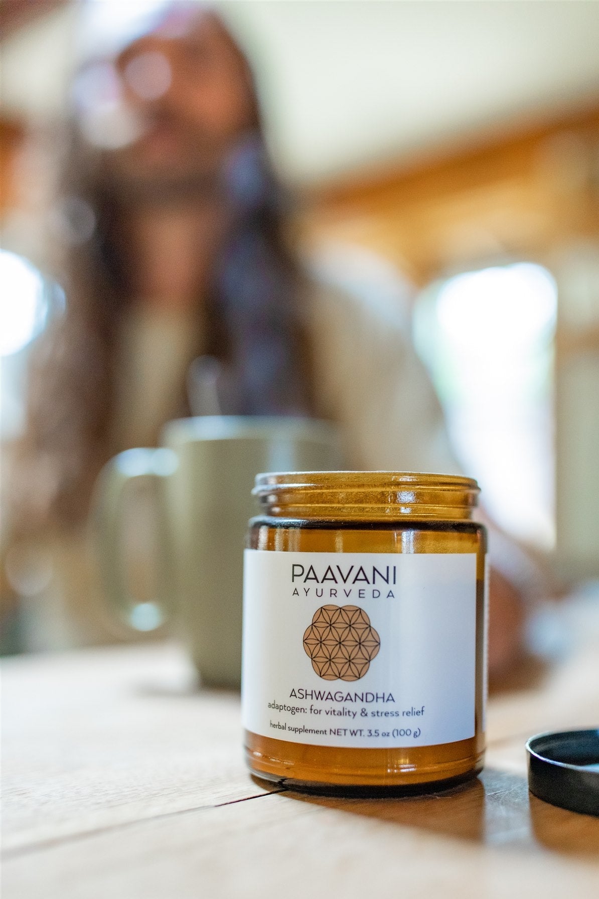 Jar of Paavani Ayurveda Ashwagandha on a table with a blurred background